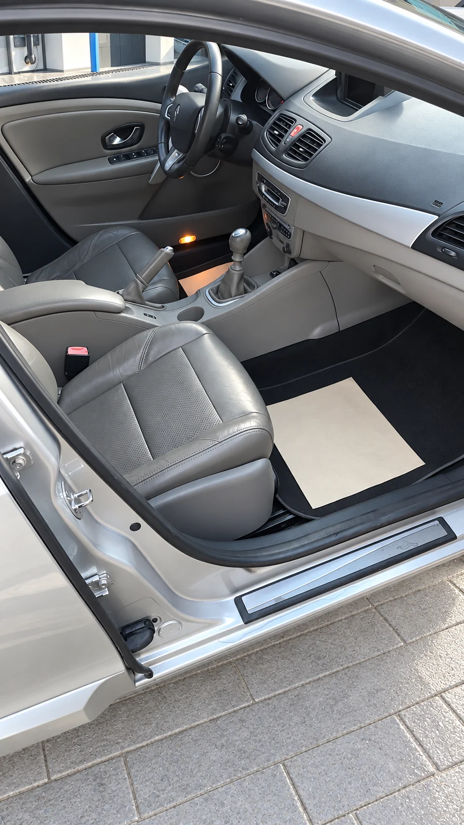 Renault Fluence interior gris, habitáculo y asientos, en un lavadero con ambientación recreada.