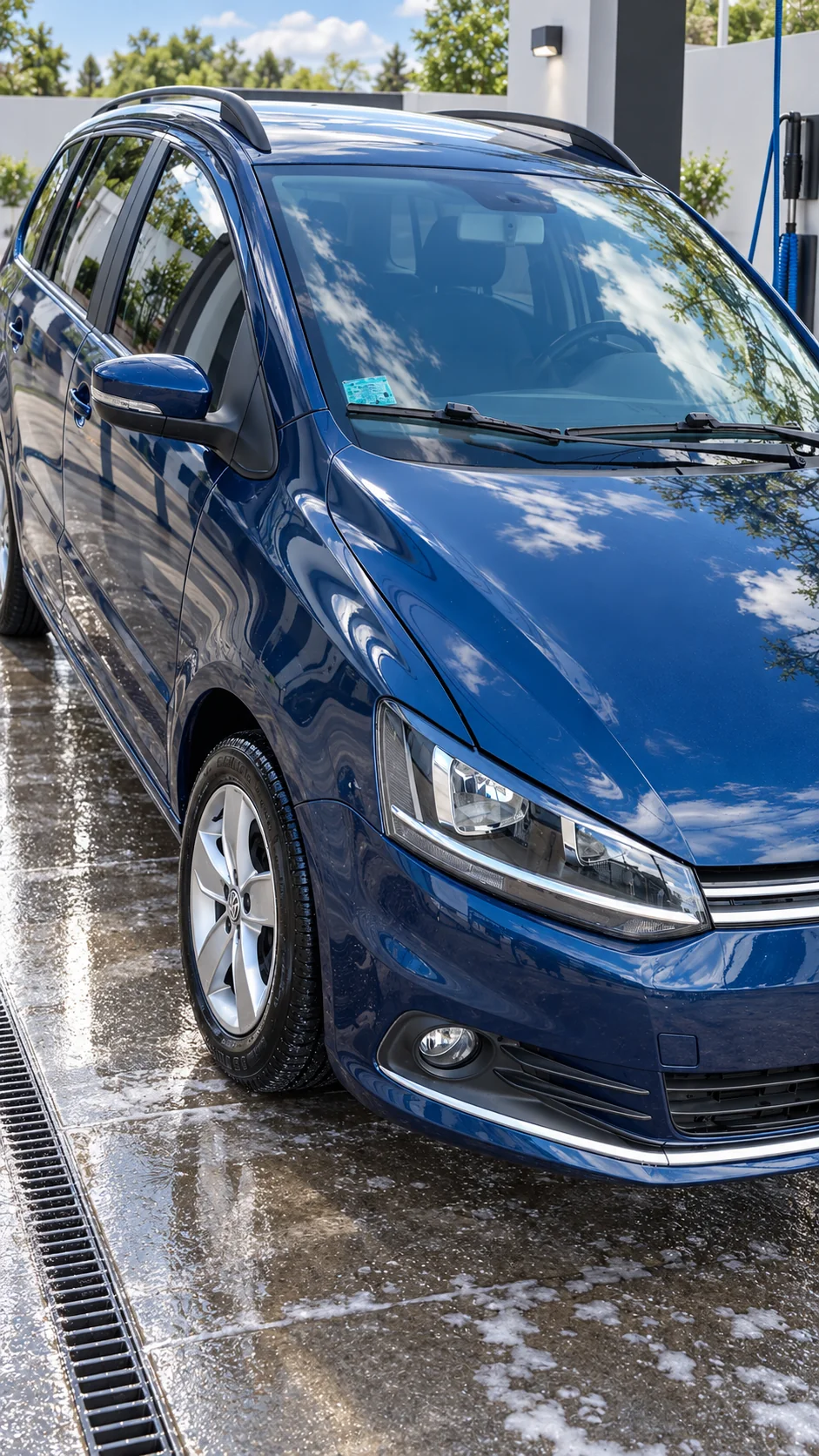 Volkswagen Suran azul, vista delantera, en un lavadero con ambientación recreada.