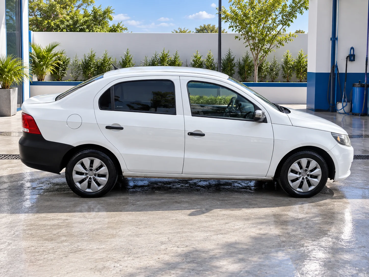 Volkswagen Voyage blanco, vista lateral, en un lavadero con ambientación recreada.